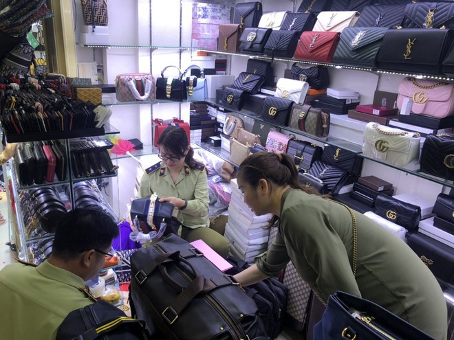 Cơ quan chức năng đang kiểm tra mặt hàng túi xách, phụ kiện thời trang có thể giả nhãn Burberry, Lacoste, Gucci, Chanel, LV... Ảnh: PV