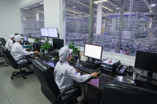 Các nhân viên tại nhà máy Vinamilk ở Bình Dương đang vận hành dây chuyền sản xuất sữa hiện đại hoàn toàn tự động hóa qua hệ thống máy tính. Ảnh: TL
