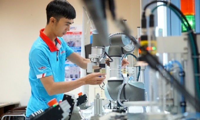 Người công nhân đang điều khiển robot tại Trung tâm Đào tạo và Chuyển giao Công nghệ Việt - Nhật, TP. HCM. Ảnh: VNE