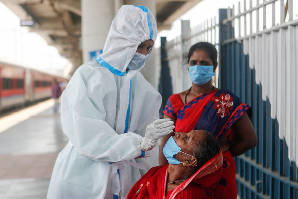 Nhân viên y tế lấy mẫu xét nghiệm Covid-19 cho người dân ở một nhà ga xe lửa tại Mumbai, Ấn Độ. Ảnh: Reuters