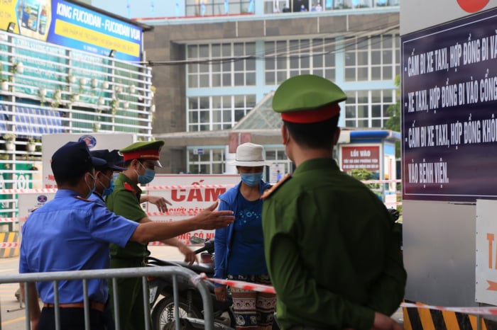 Trước cổng bệnh viện, lực lượng công an, bảo vệ chốt chặn lối ra vào và giải thích cho người dân nơi này không tiếp nhận bệnh nhân do tình hình dịch Covid-19.