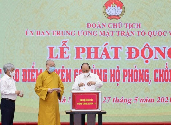 Chủ tịch nước Nguyễn Xuân Phúc trao tiền ủng hộ công tác phòng chống dịch Covid-19.