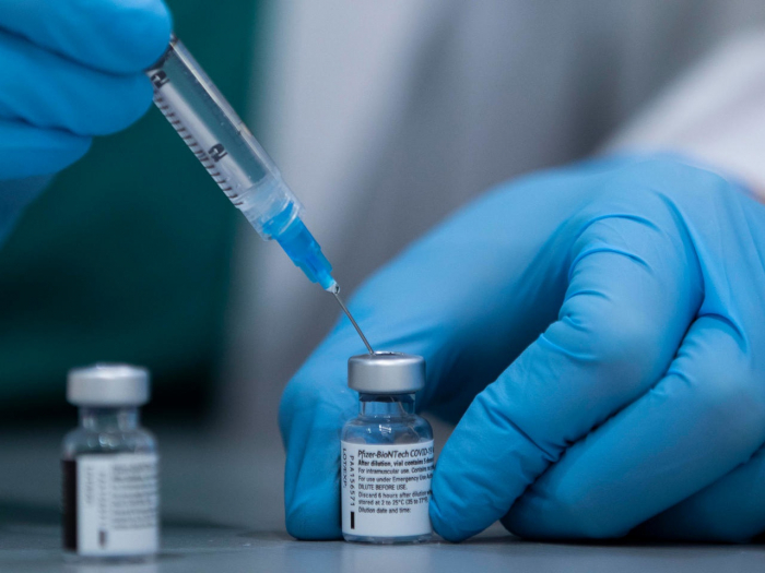 Nhân viên y tế chuẩn bị một mũi tiêm vaccine Covid-19 của hãng Pfizer - BioNTech. Ảnh: AFP.
