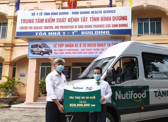 Đại diện Quỹ Phát triển Tài năng Việt của Ông Bầu trao xe ô tô 16 chỗ cho Trung tâm Kiểm soát Bệnh tật tỉnh Bình Dương. Ảnh: TL.
