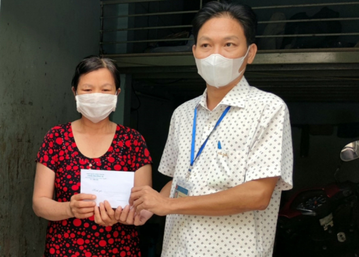 Bà Nguyễn Thị Phượng nhận tiền hỗ trợ từ cán bộ phường.