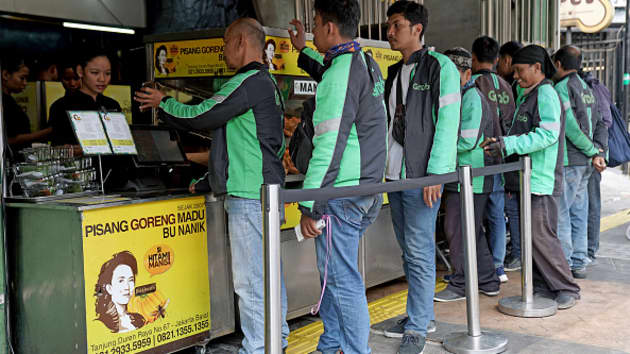 Các tài xế GrabFood đang chờ lấy hàng tại một cửa hàng ăn nhanh ở Jakarta, Indonesia. Ảnh: Getty Images.
