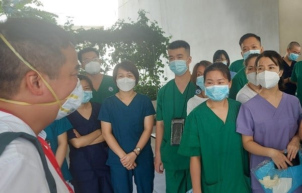 PGS.TS Nguyễn Lân Hiếu (ngoài cùng bên trái) đang làm trao đổi với các y, bác sĩ Trung tâm Hồi sức tích cực bệnh nhân Covid-19 tại Bình Dương. Ảnh: PV.