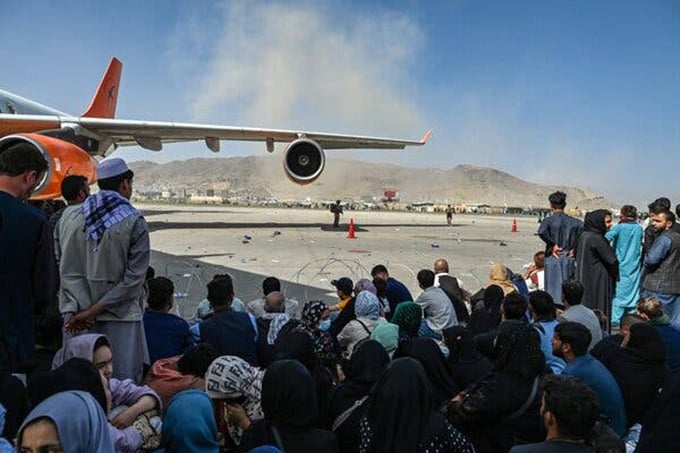 Tại sân bay Kabul, một người có ảnh hưởng ủng hộ Taliban đã phân trần trực tuyến qua mạng xã hội về chính sách của nhà nước mới với những người Afghanistan đang cố gắng di tản. Ảnh: The New York Times