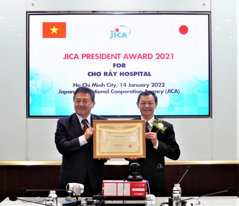 Ông Shimizu Akira, Trưởng đại diện Văn phòng JICA Việt Nam (trái) trao bằng khen cho TS.BS. Nguyễn Tri Thức (phải) - Giám đốc Bệnh viện Chợ Rẫy. Ảnh: JICA.