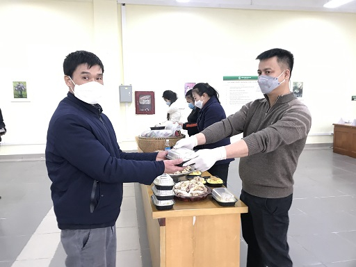 Bệnh nhân và người nhà bệnh nhân nhận xuất xôi Phú Thượng miễn phí tại Gian hàng Tết 0 đồng của Bệnh viện Bạch Mai.