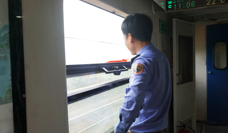 Phó trưởng tàu Hữu Quỳnh đang làm tín hiệu an toàn khi tàu chạy qua các ga dọc đường.