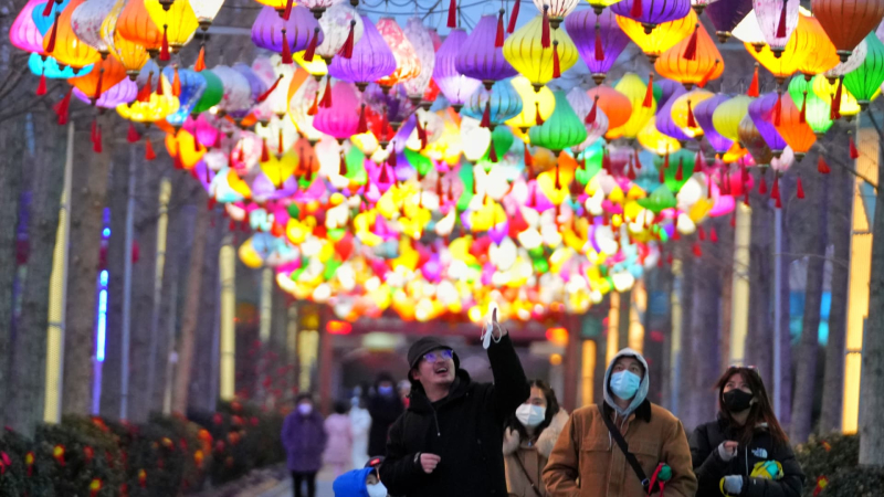 Du khách đứng dưới đèn lồng tại khu du lịch Bắc Kinh. Ảnh: CNBC.