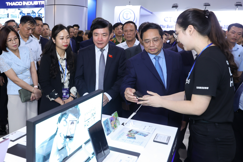 Thủ tướng Phạm Minh Chính cùng các đại biểu tham quan gian hàng trưng bày sản phẩm đổi mới sáng tạo của các doanh nghiệp. Ảnh: VGP