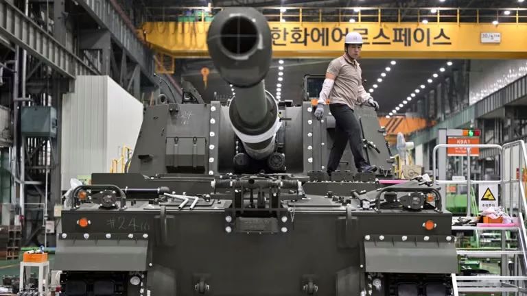 Một kỹ sư đứng trên xe bắn pháo K9, một trong các sản phẩm chủ đạo của Hanwha Aerospace. Ảnh: AFP