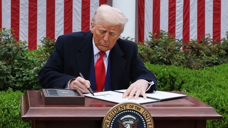 Tổng thống Donald Trump ký sắc lệnh hành pháp về thuế quan tại Vườn Hồng ở Nhà Trắng vào ngày 2/4/2025. Ảnh: Reuters