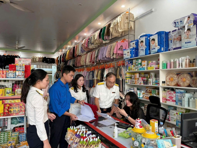 Cán bộ thuế hướng dẫn hộ kinh doanh trong quá trình kê khai thuế. Ảnh: DươngHải/BNEWS/TTXVN