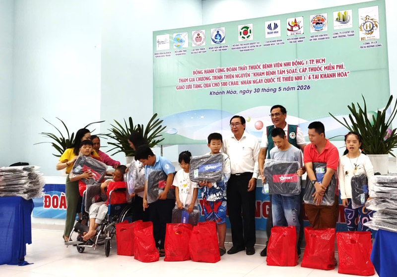TS.BS.Lê Hữu Thọ, Chủ tịch Hội Bảo trợ người khuyết tật, bệnh nhân nghèo và quyền trẻ em tỉnh Khánh (áo xanh, giữa); PGS.TS.Ngô Minh Xuân (áo trắng, giữa) cùng lên trao quà cho các em