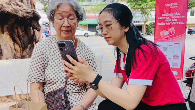 Nhân viên Viettel đến tận nơi hỗ trợ khách hàng cao tuổi hoàn tất thủ tục xác thực thuê bao.