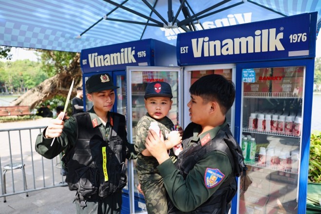 Em bé được lực lượng cảnh sát cơ động chăm sóc, trao tặng sản phẩm dinh dưỡng Vinamilk tại chương trình. Ảnh: Vi Nam
