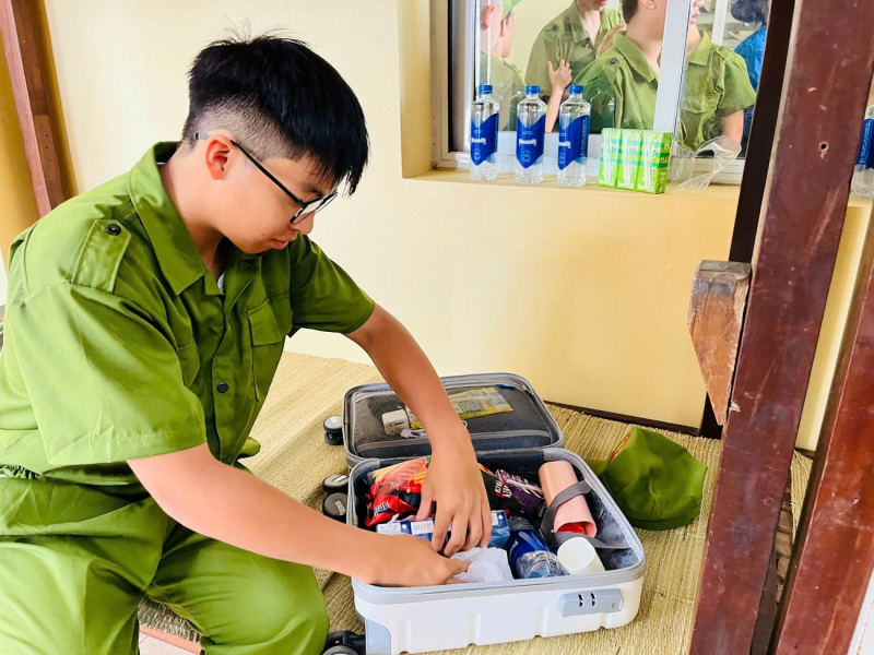 Phúc Khang học cách tự xắp xếp đồ dùng trong ngày đầu tham gia “Học làm chiến sĩ công an”. Ảnh: VN. 