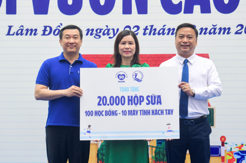 Ông Đỗ Thanh Tuấn - Giám đốc Đối ngoại Vinamilk (bên trái) và ông Đinh Tiến Hải - Giám đốc Quỹ Bảo trợ Trẻ em Việt Nam - trao bảng tượng trưng các phần quà thiết thực cho đại diện Trường Tiểu học An Hiệp, xã Hiệp Thạnh (Ảnh: Hải An).