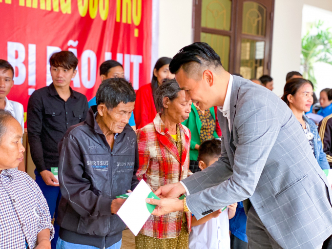 Phó chủ tịch Hội doanh nhân trẻ Hà Nội Nguyễn Phúc Long trao quà cho bà con vùng lũ